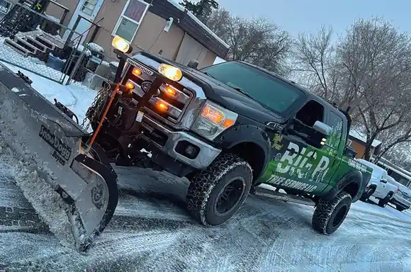 Big R's wrapped pickup with a snow plow on a snowy Yakima street